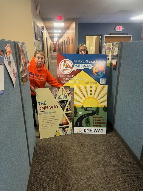 Photo of staff and DMH Way Posters.